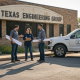 Engineers outside Texas office with blueprints