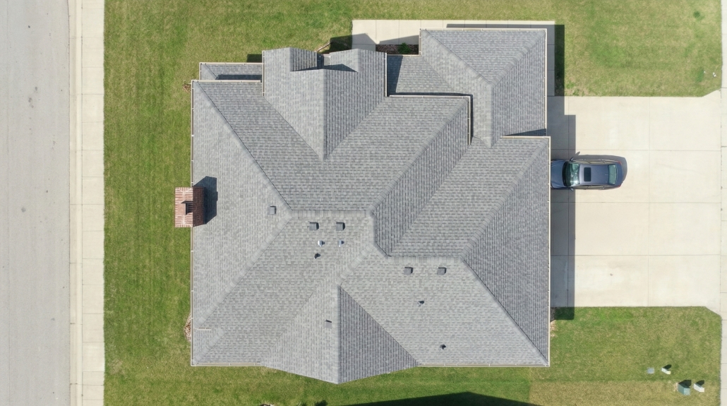 Aerial top-down view of a residential roof showing multiple roof planes and driveway