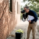 Forensic engineer examines cracked building wall